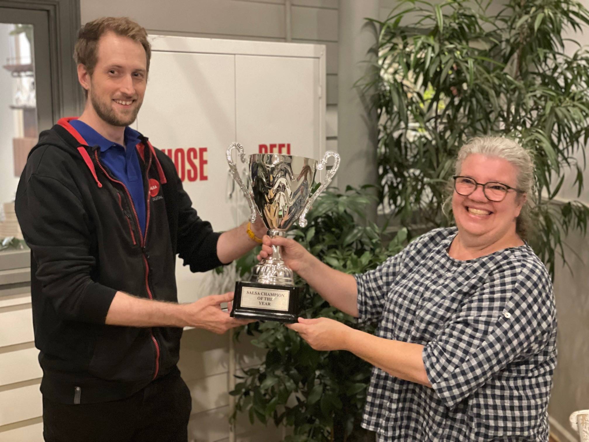 Salsa’s 2023 champion, Kate Swayne, officially hands over the cup to Alan Cole!